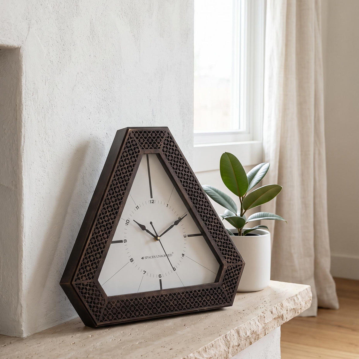 Spaces Unhooked logo above the brass-toned centre cap on a triangular bronze dial
