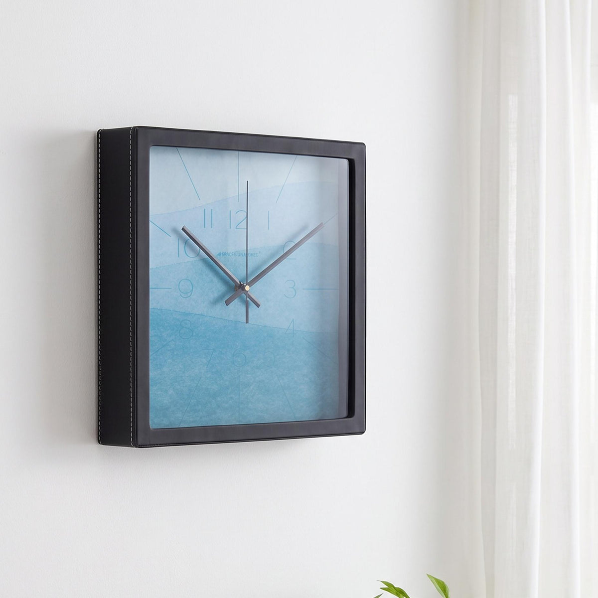Sky blue watercolour wall clock on a nursery or study wall near a desk