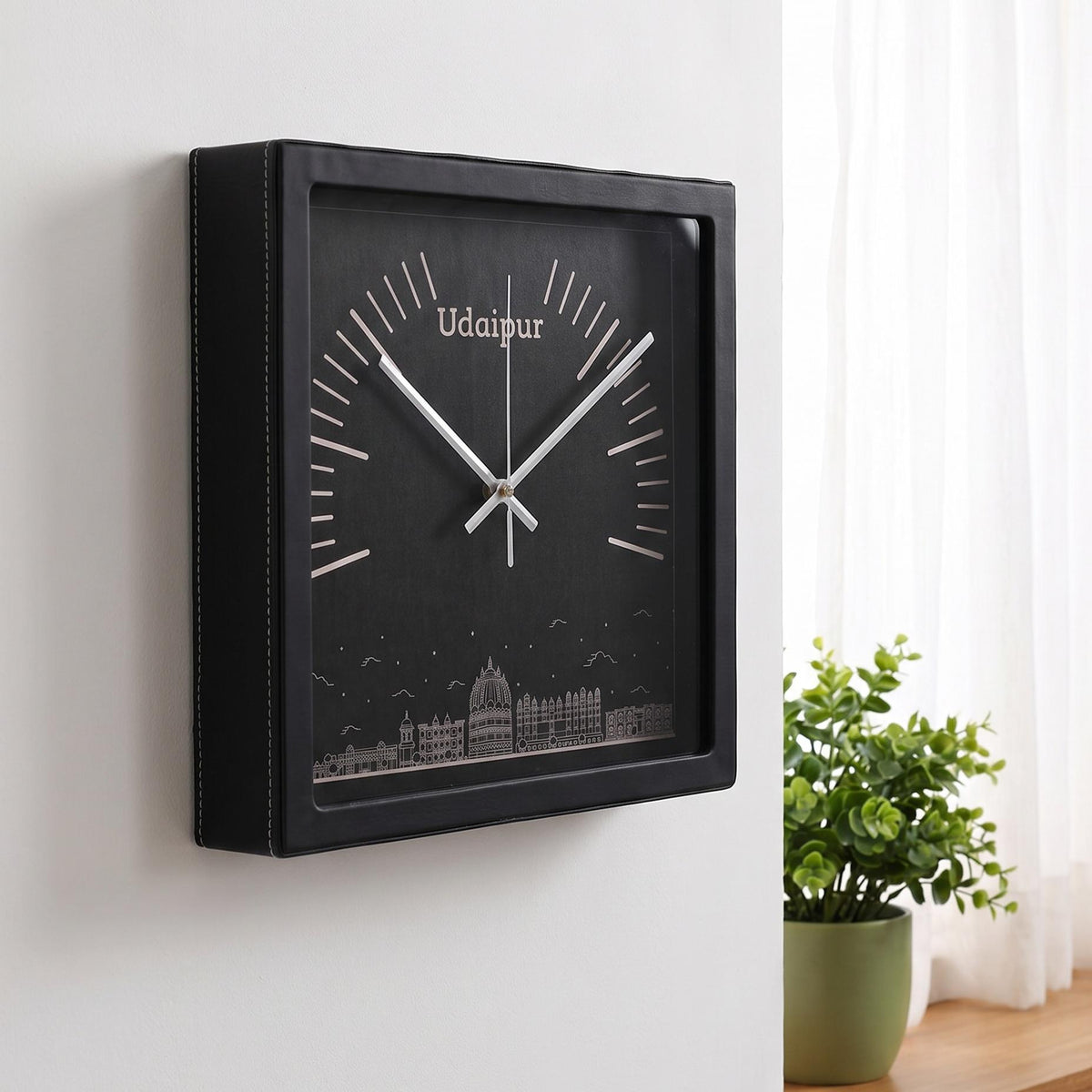 Udaipur skyline wall clock on a hallway wall beside a family photograph