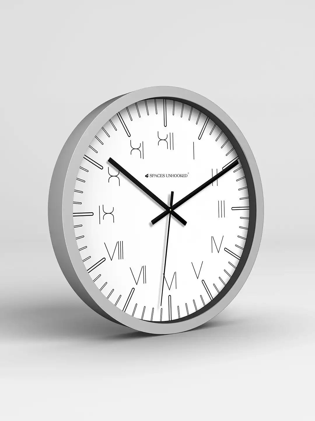 Wall clock with silver frame and white face on a light gray background
