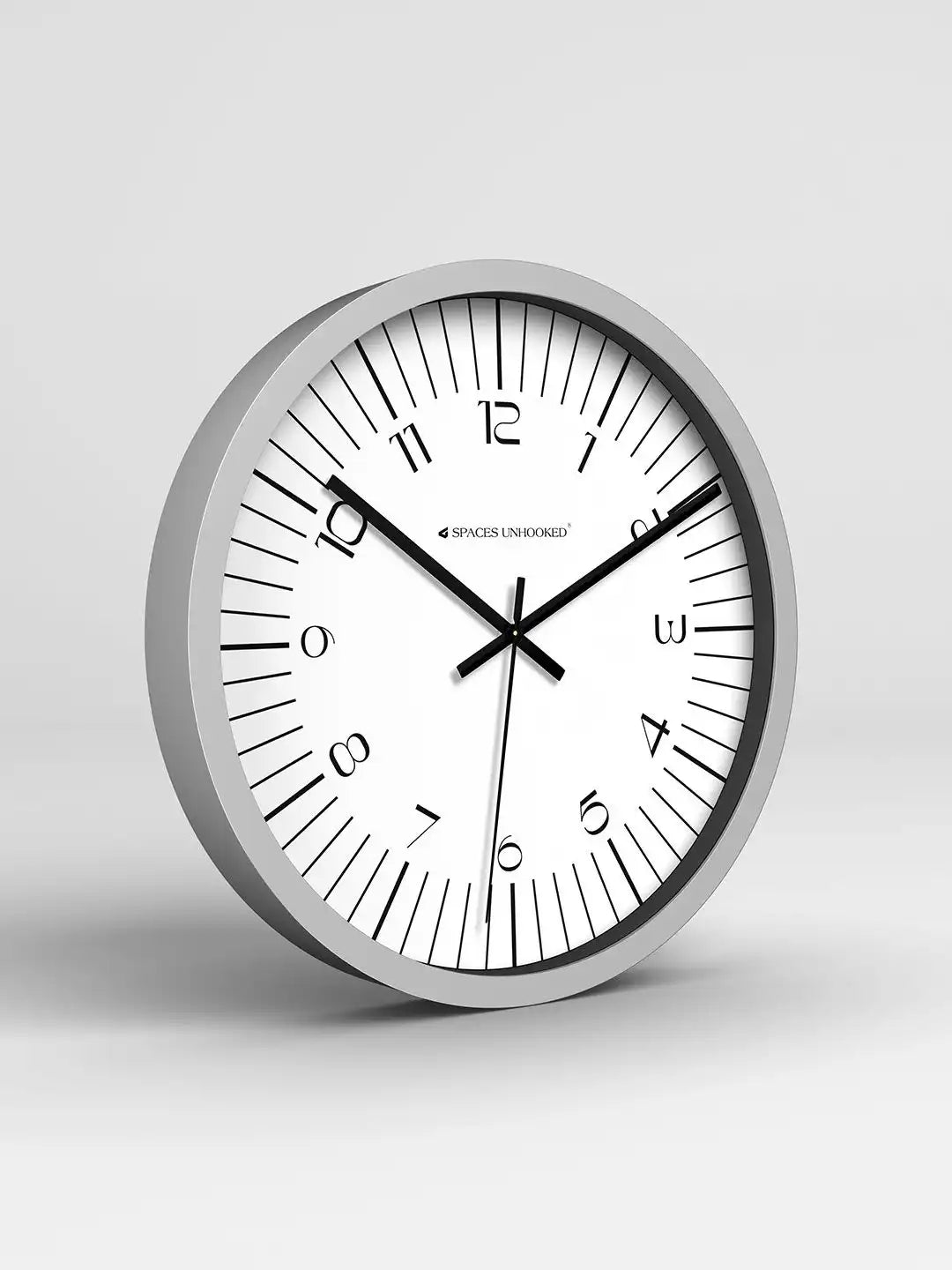Wall clock with silver frame and white face on a light gray background