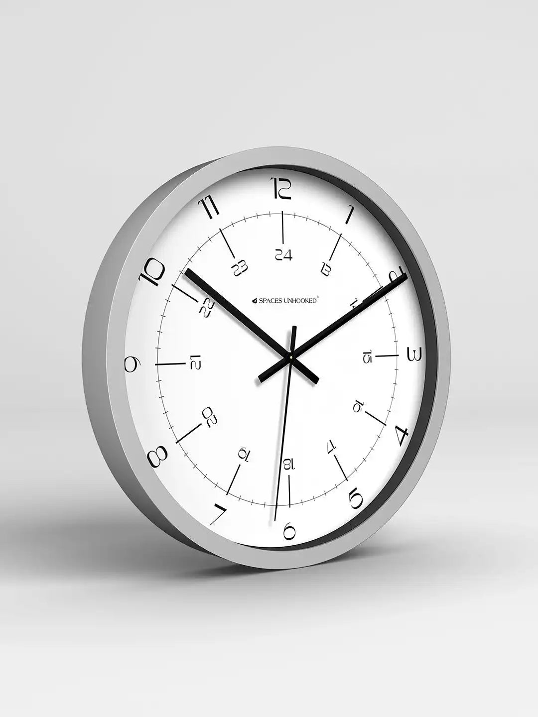 Wall clock with silver frame and white face on a light gray background