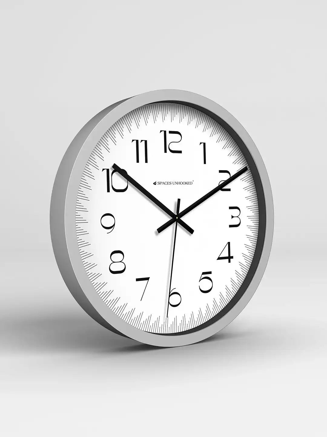 Wall clock with silver frame and white face on a light gray background