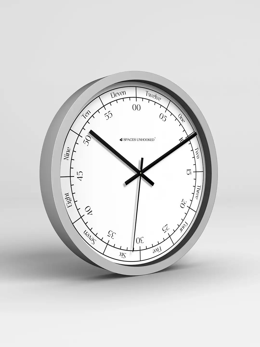 Wall clock with silver frame and white face on a light gray background