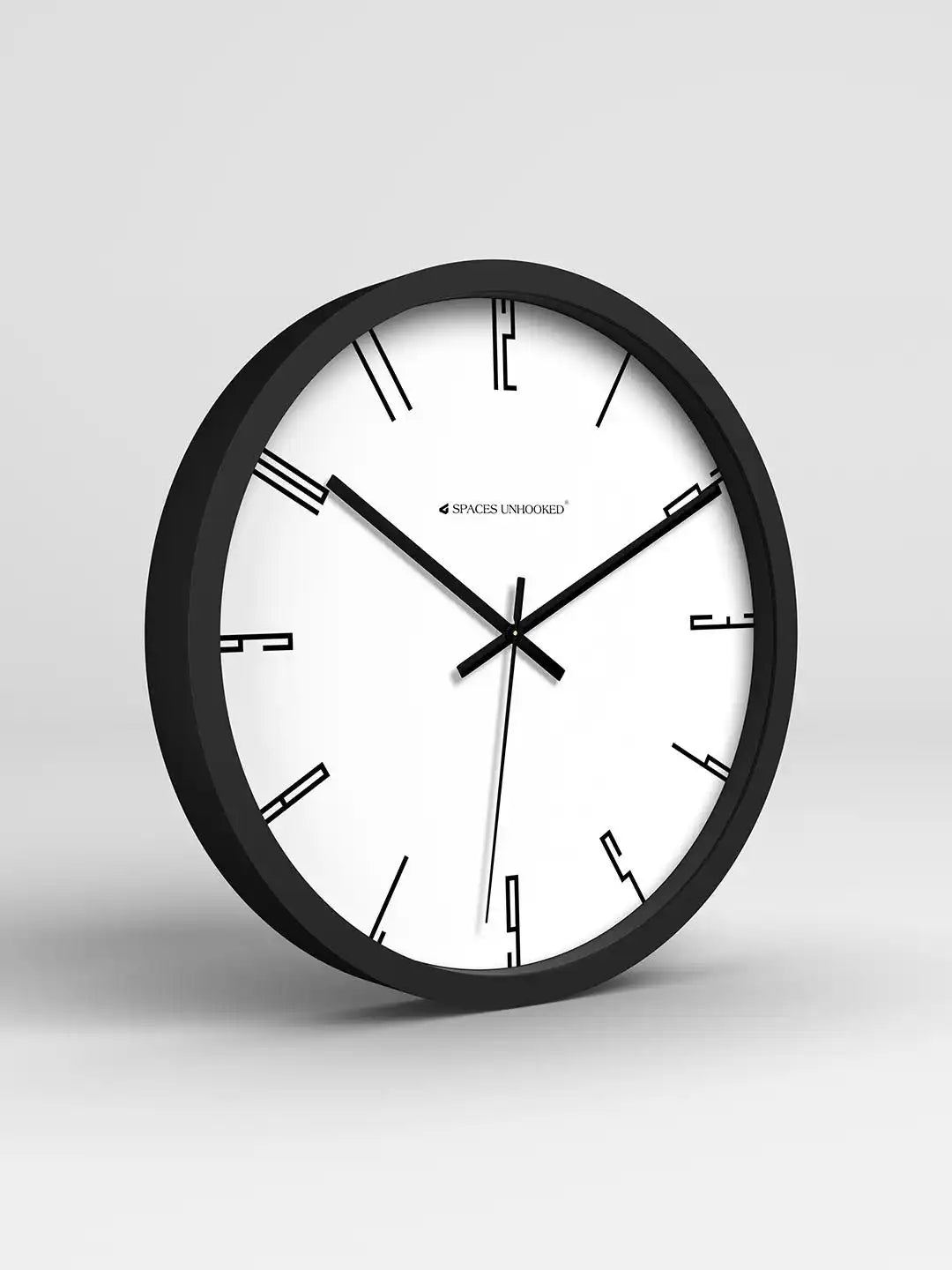 Black wall clock with white face on a light gray background