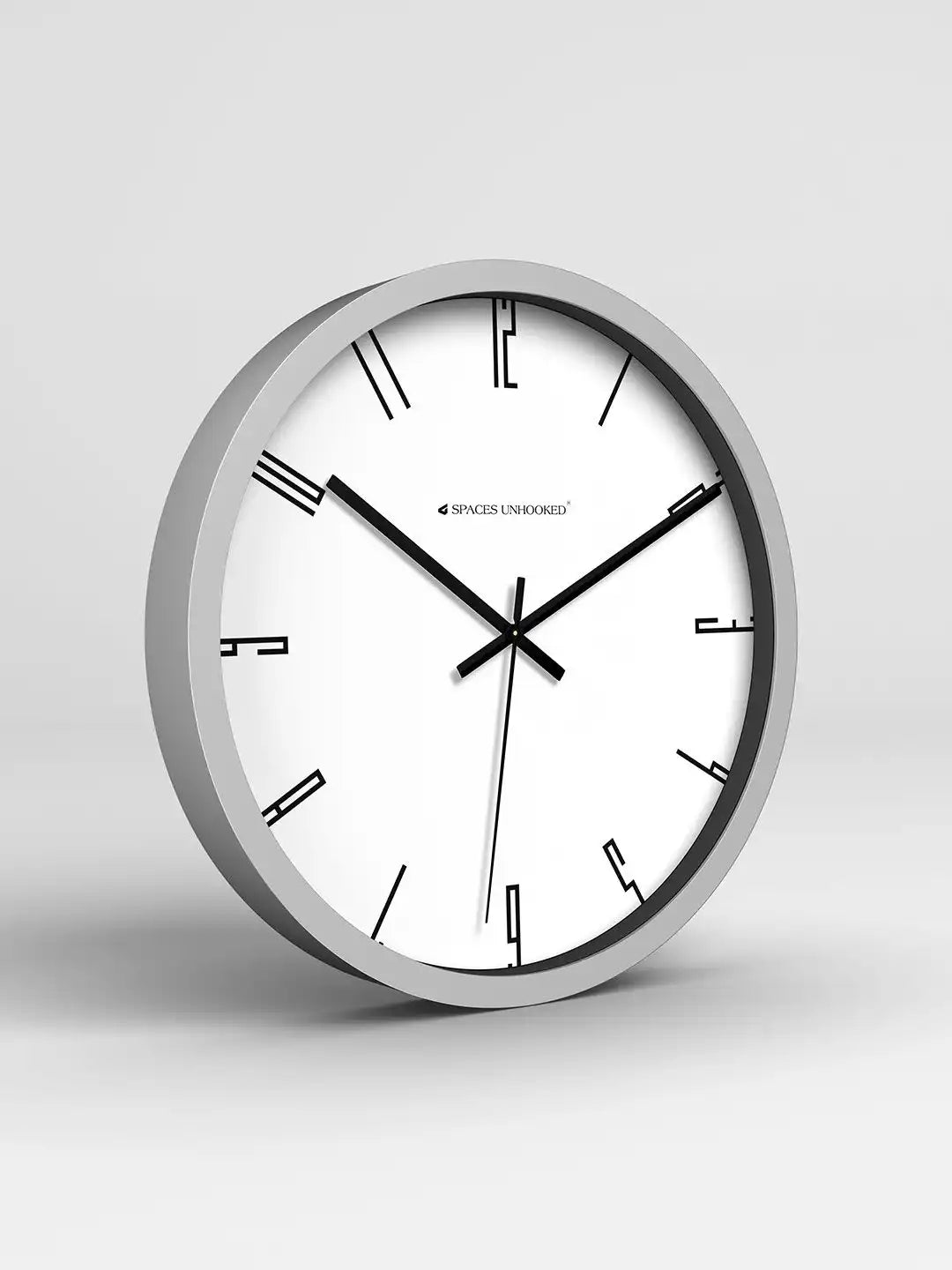 Wall clock with silver frame and white face on a light gray background