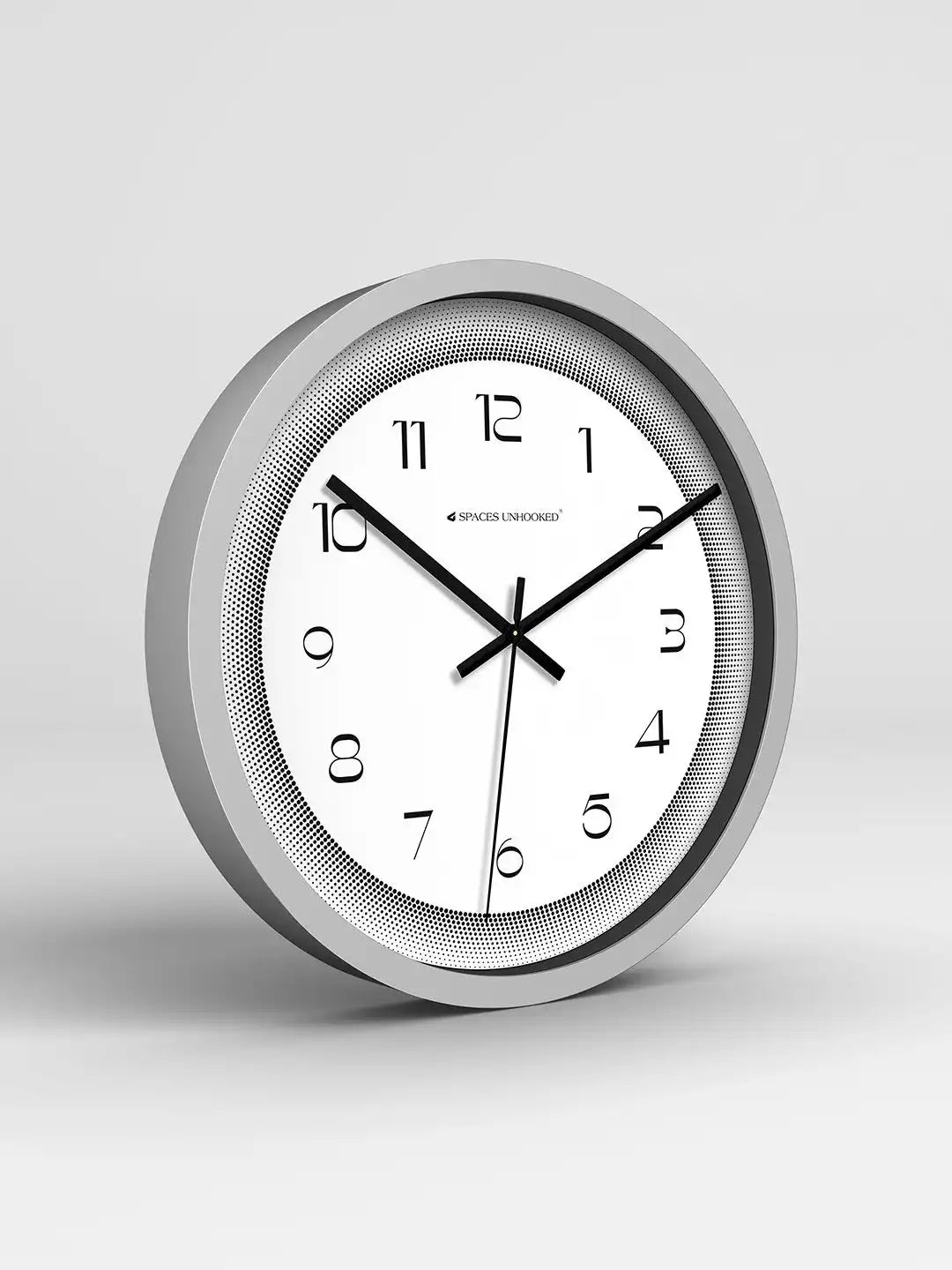 Wall clock with silver frame and white face on a light gray background