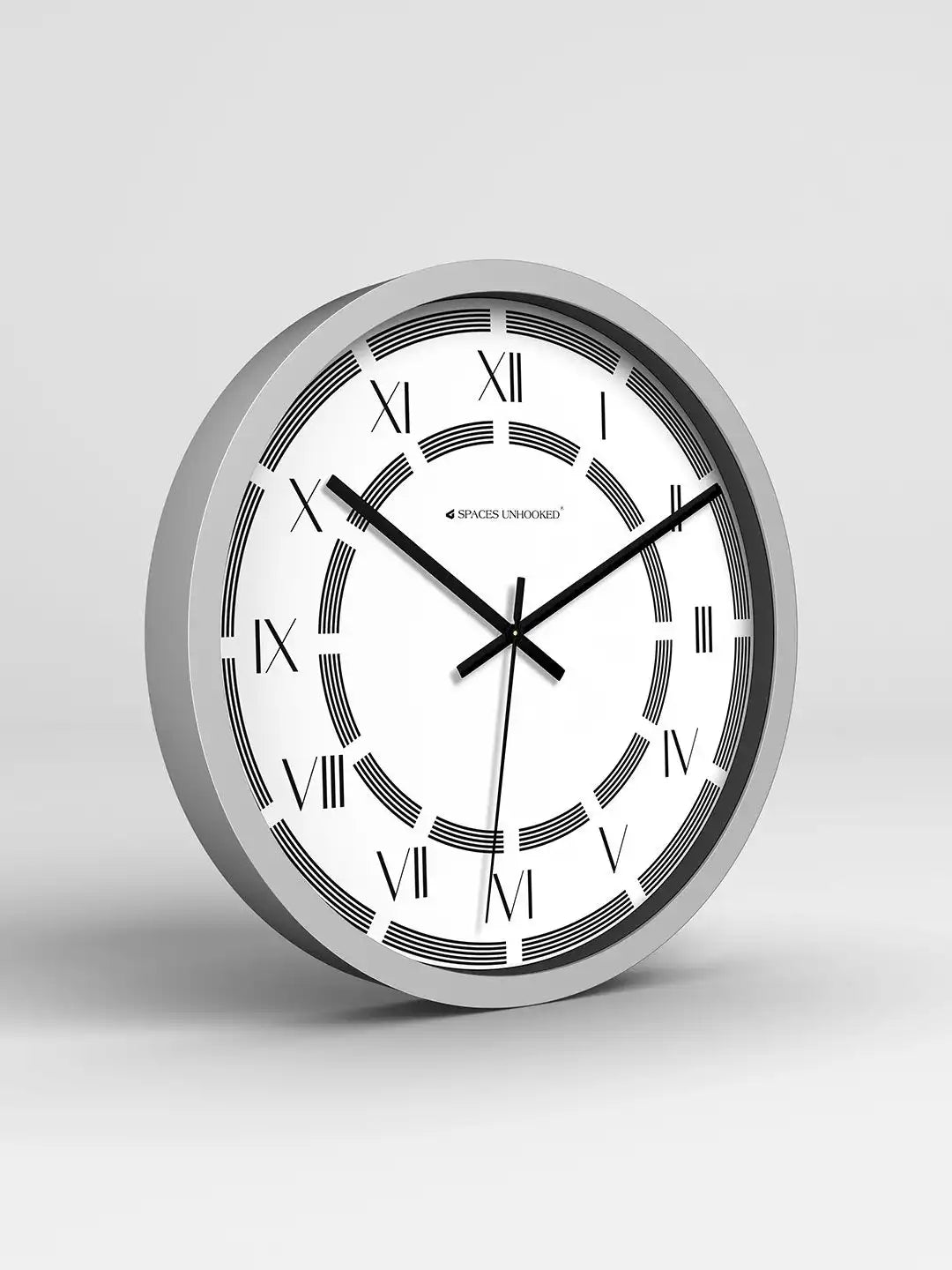 Wall clock with silver frame and white face on a light gray background