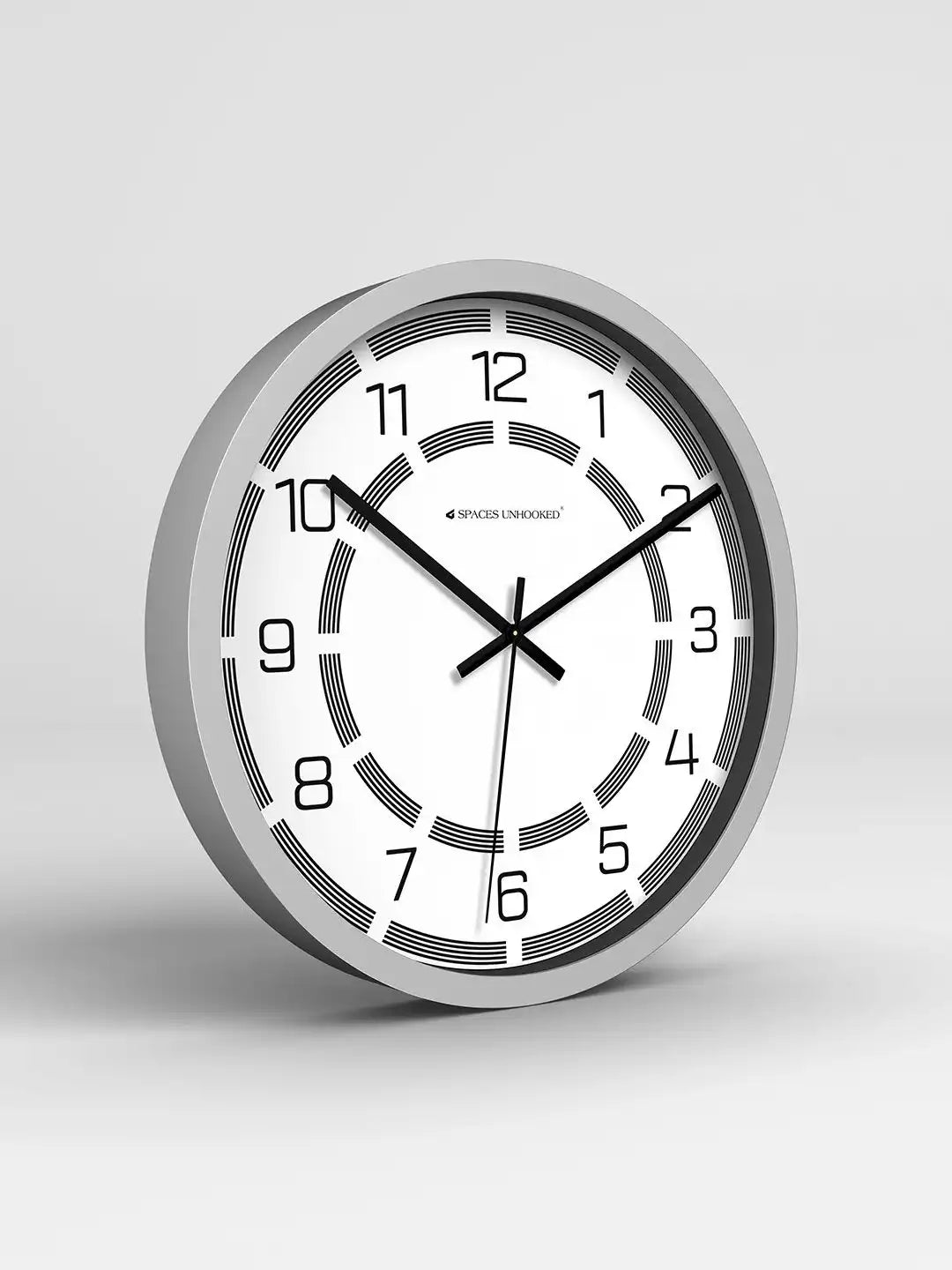 Wall clock with silver frame and white face on a light gray background