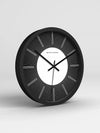 Black wall clock on a light gray background