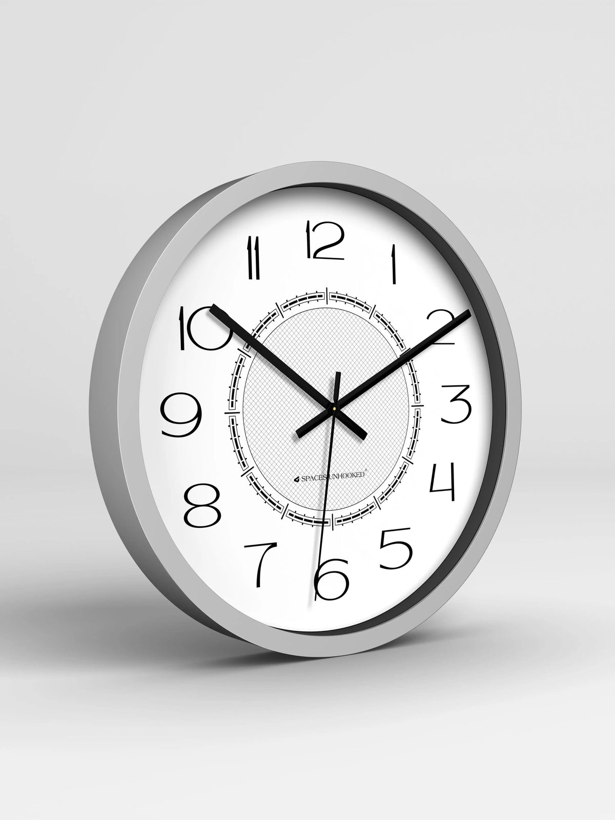 Wall clock with silver frame and white face on a light gray background