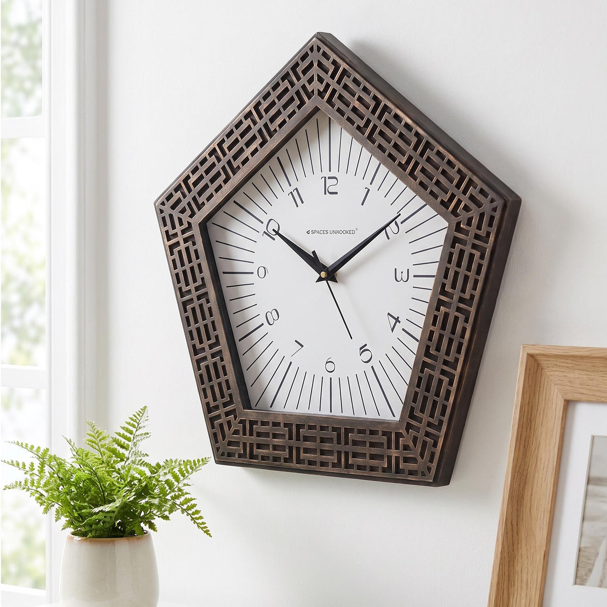 Close-up of the carved bronze-finish maze pattern on a pentagon clock frame