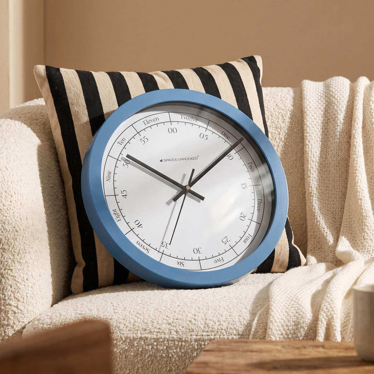 Bold blue round frame with a smooth finish around a bright white dial, close-up view