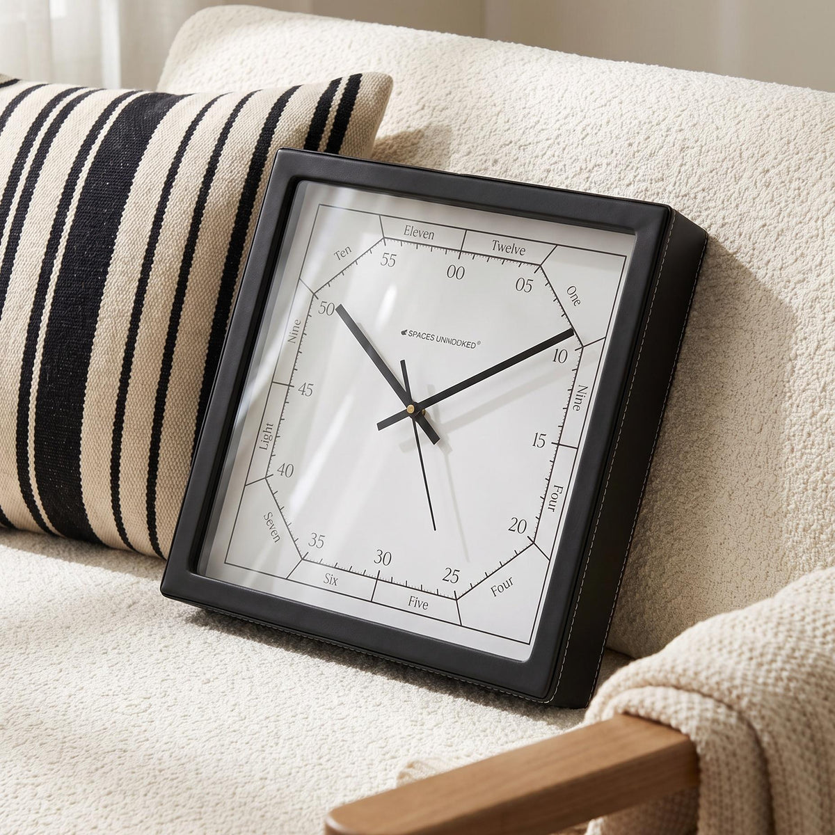 Black square wall clock frame with an even border, close-up view