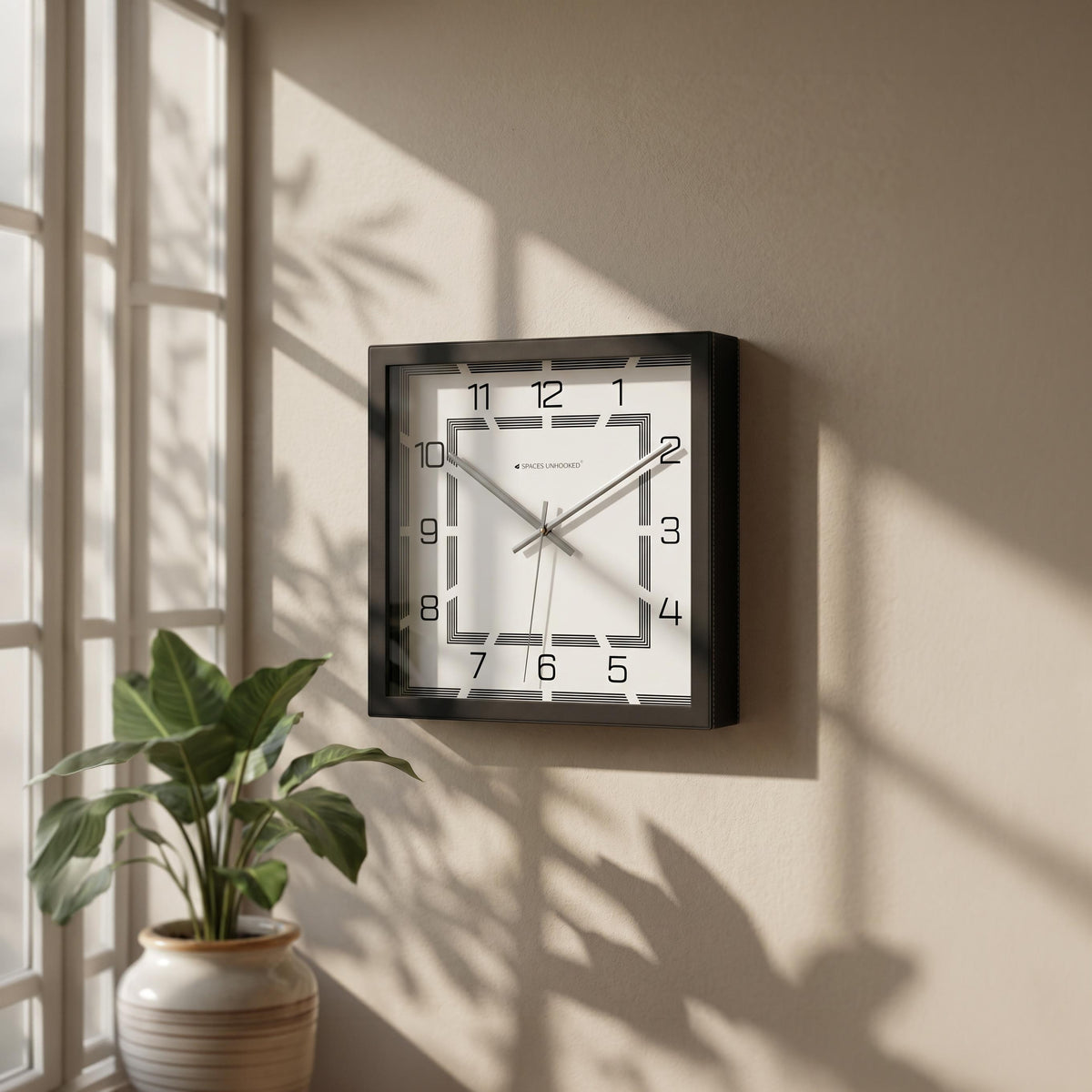 Square black and white wall clock above a bar cart in a dining area