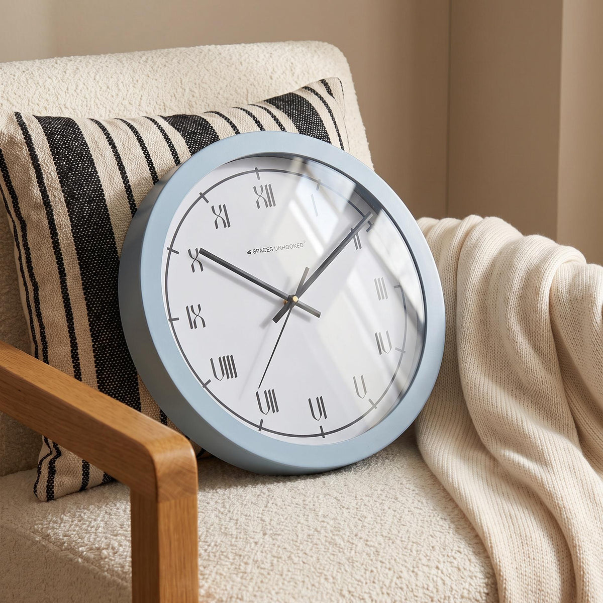Pale powder blue round frame with a soft matte look around a white Roman numeral dial