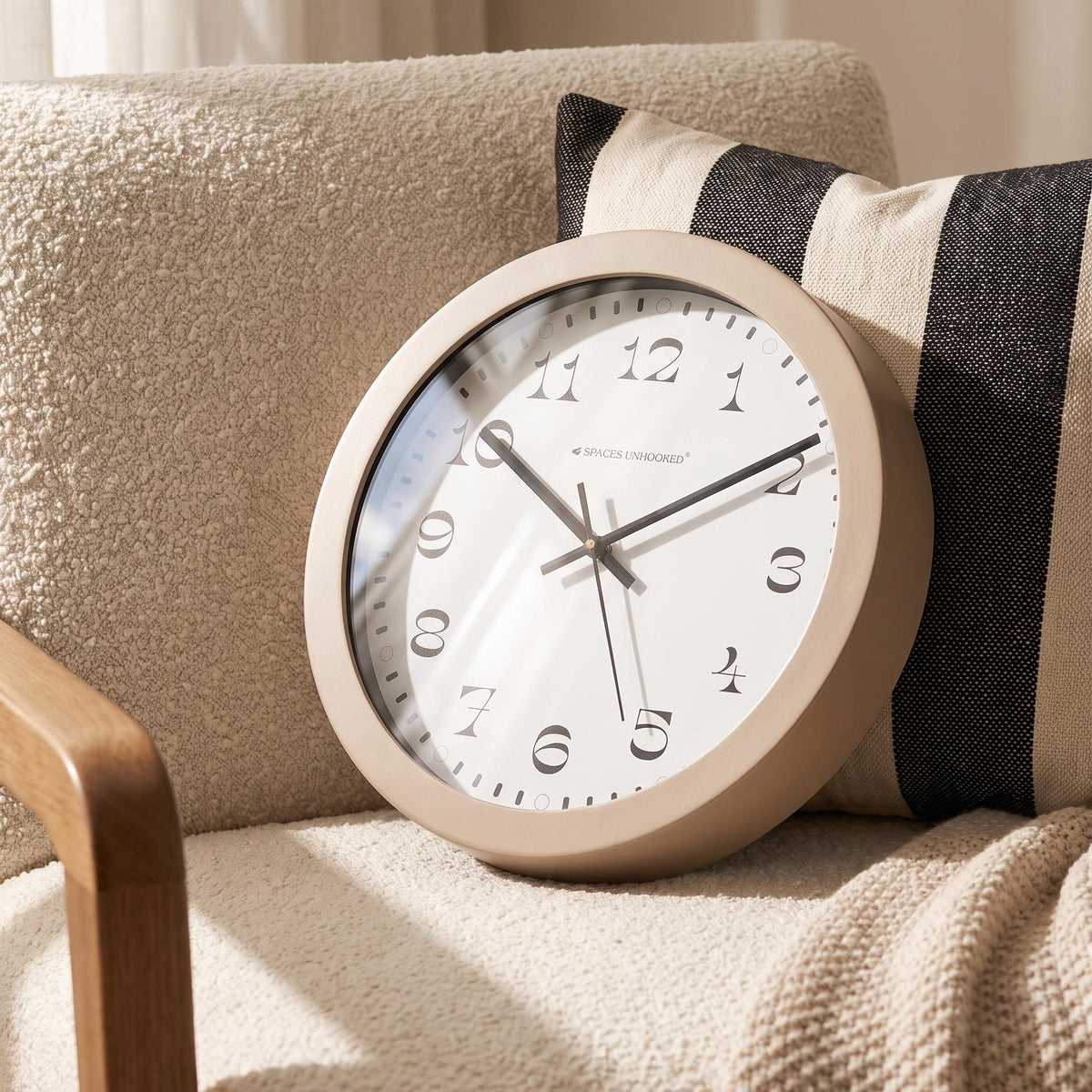 Warm taupe round frame with a smooth finish around a crisp white dial, close-up view