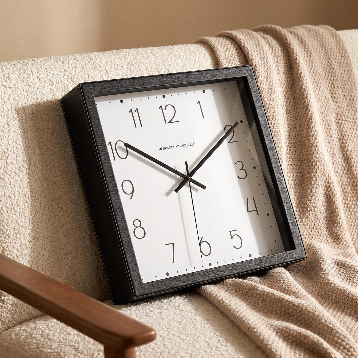 Spaces Unhooked logo above the brass-toned centre cap on a dotted dial clock