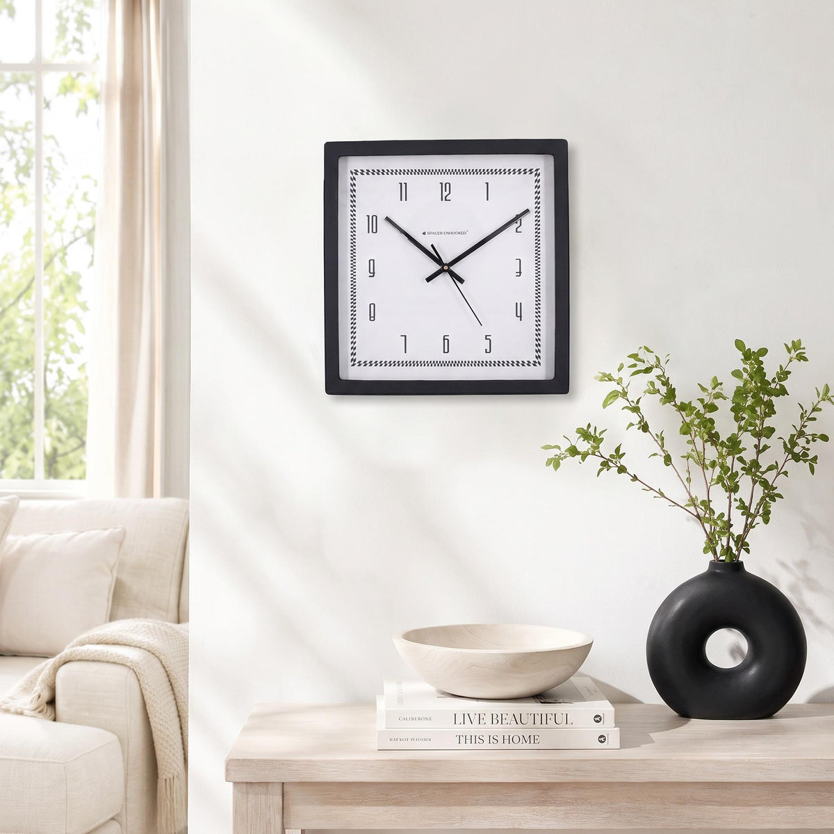 Spaces Unhooked logo above the brass-toned centre cap on a checked border clock dial
