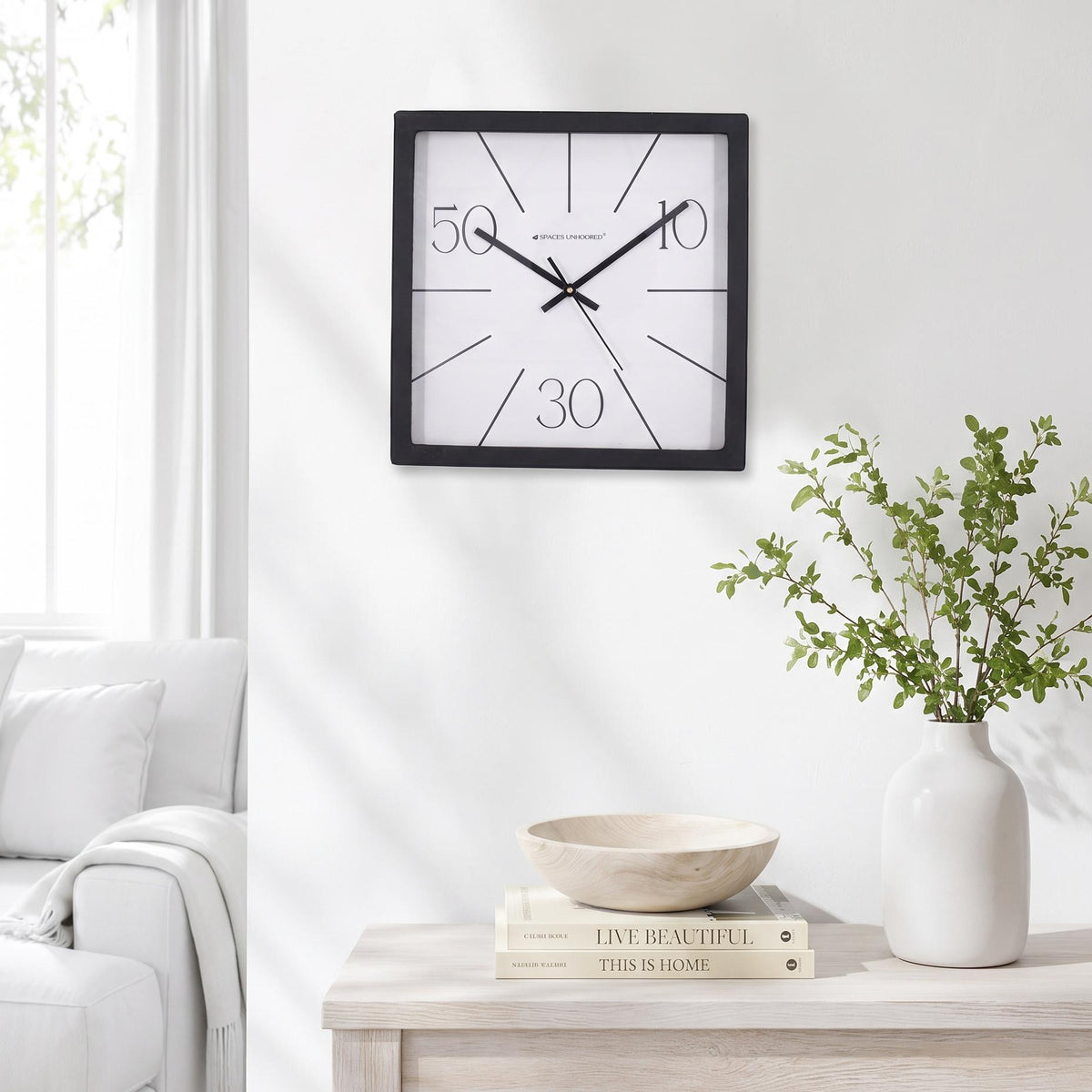 Spaces Unhooked logo above the brass-toned centre cap on a radial line clock dial