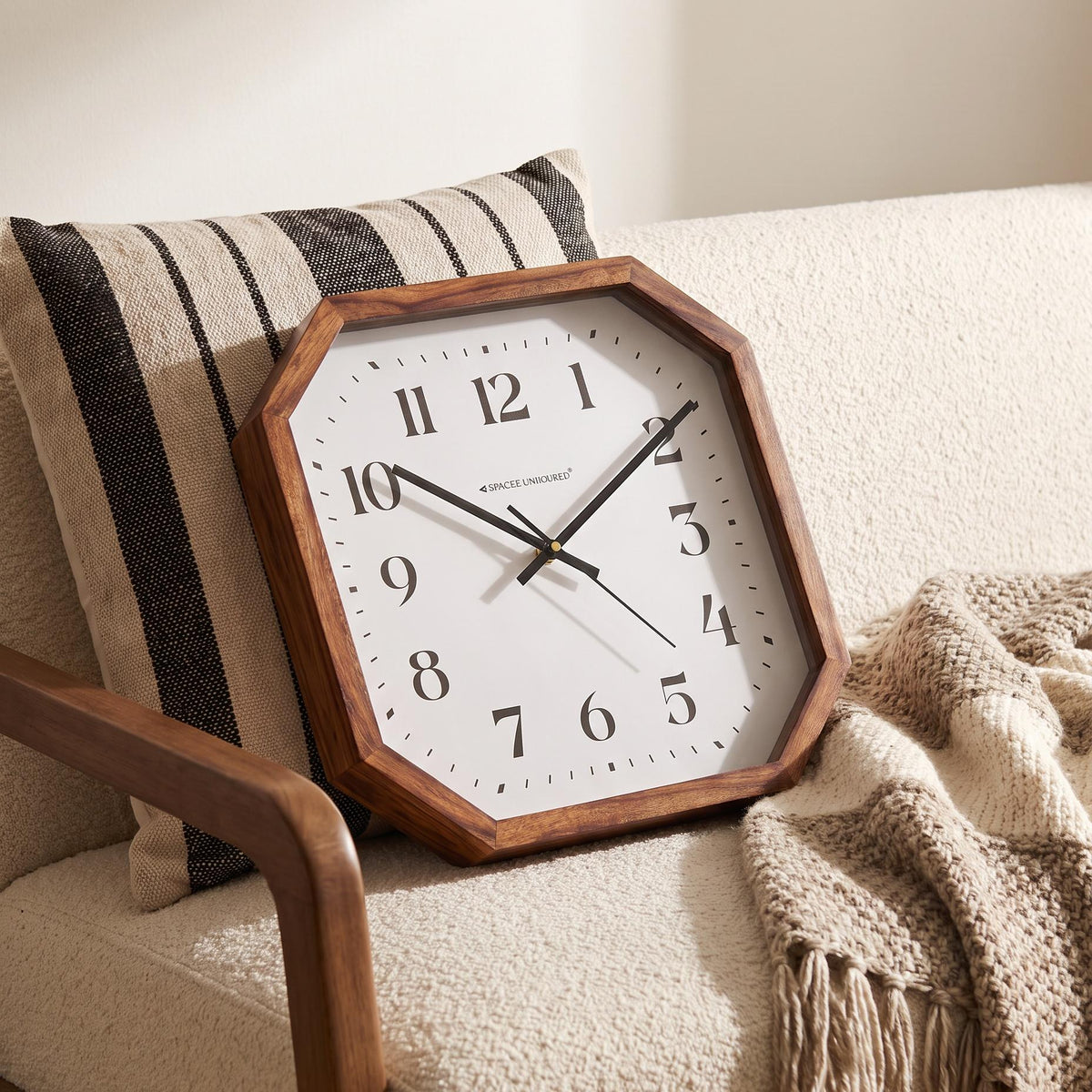 Spaces Unhooked logo above the brass-toned centre cap on an octagonal wooden wall clock dial