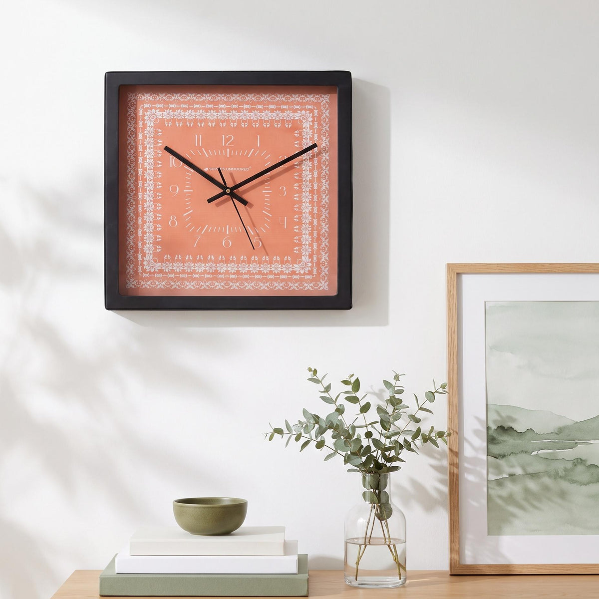 Coral floral border wall clock on a hallway wall beside a mirror
