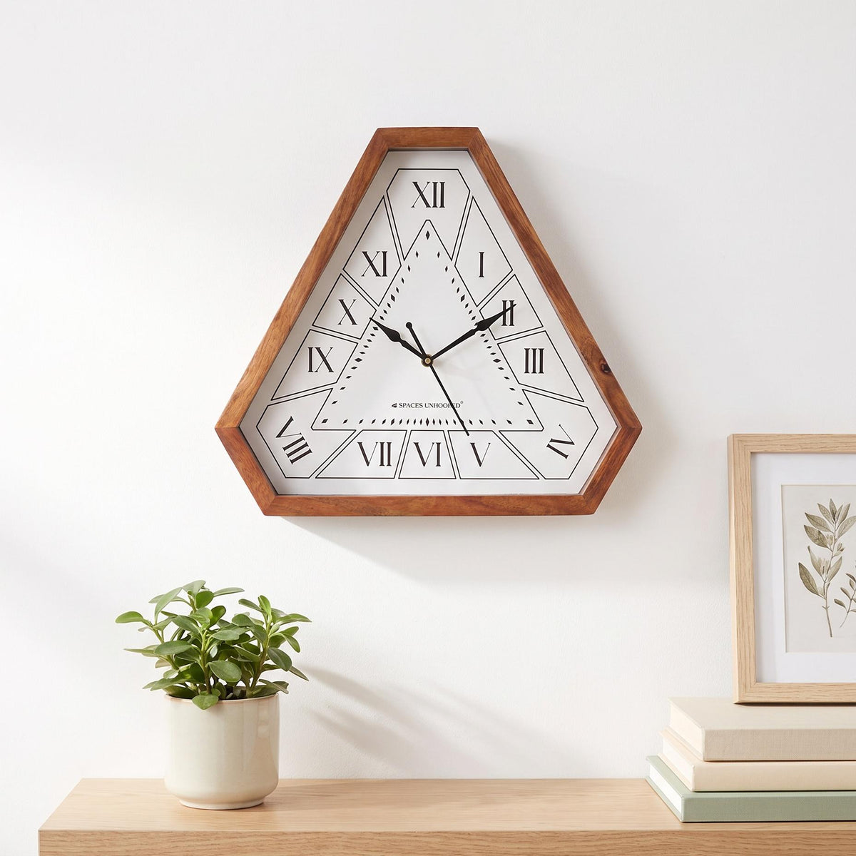 Rich brown triangular wooden frame with visible grain on a Roman numeral wall clock, close-up