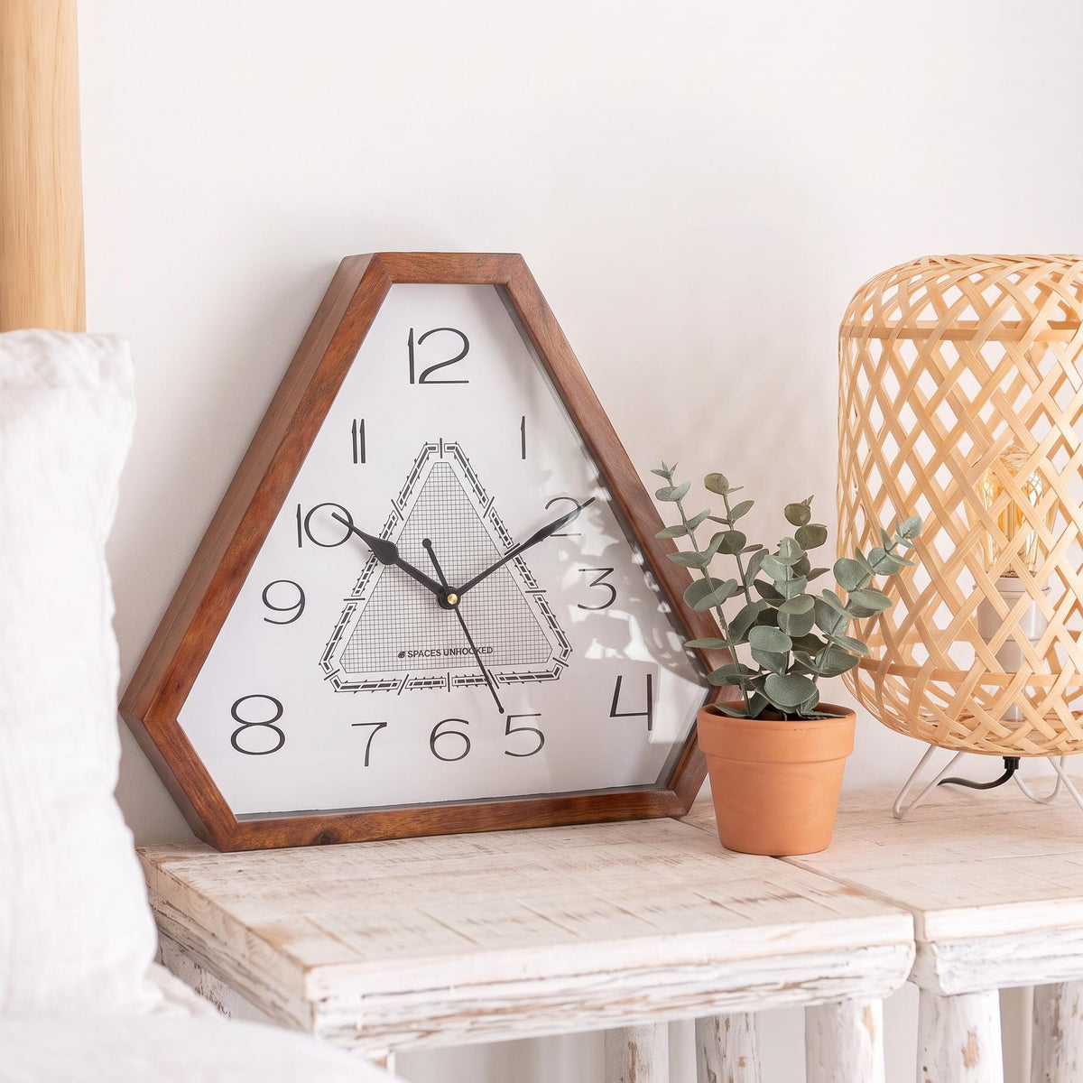 Warm glossy brown triangular wooden frame with natural grain and clipped corners, close-up