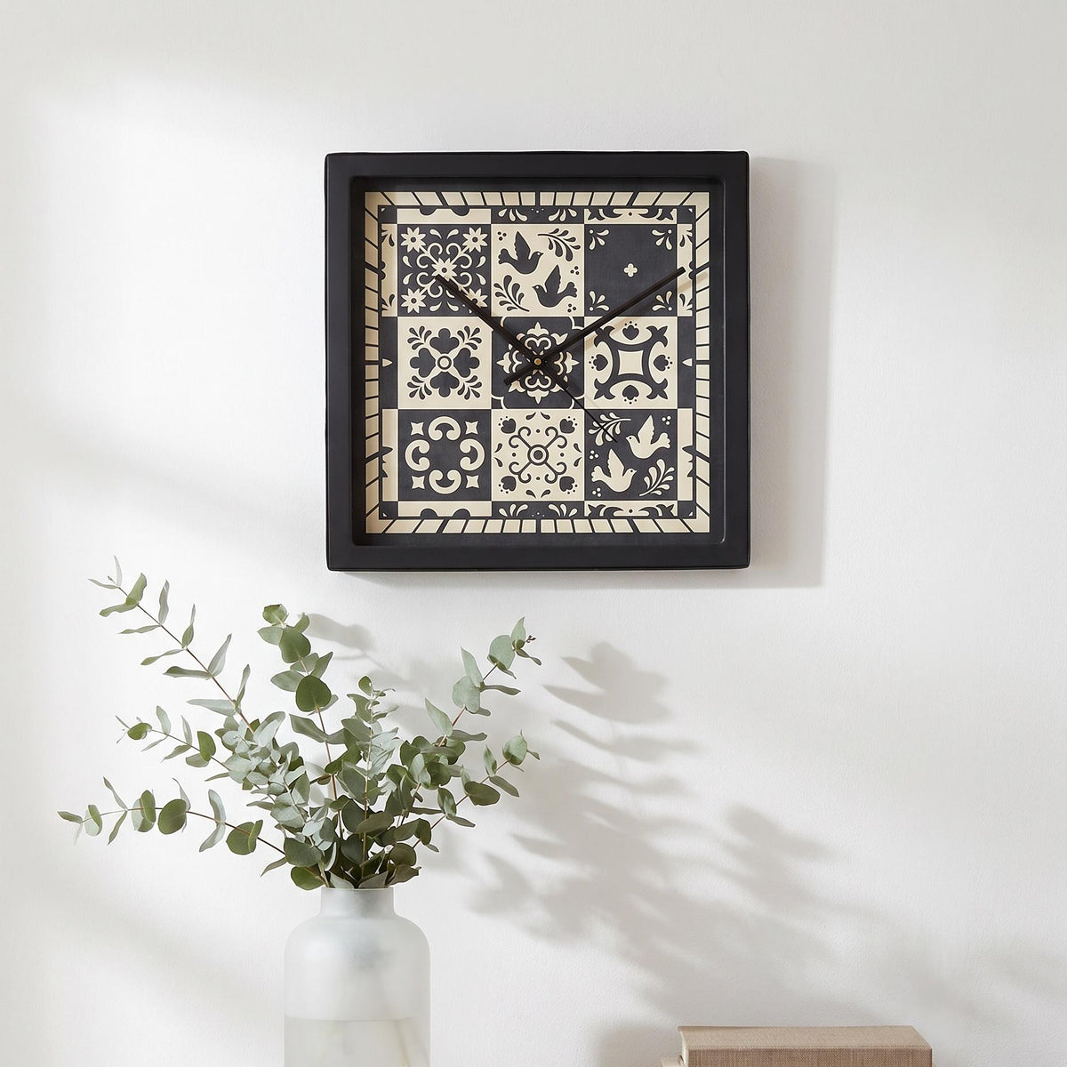 Spaces Unhooked logo above the brass-toned centre cap on a folk art tile clock dial