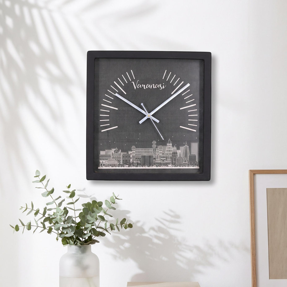 Black square frame and clear cover of a Varanasi skyline wall clock, close-up view