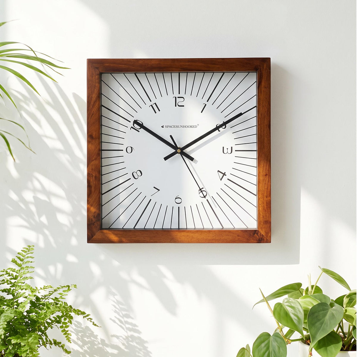 Slim numerals 1 to 12 in a loose ring inside a burst of lines on a square clock dial