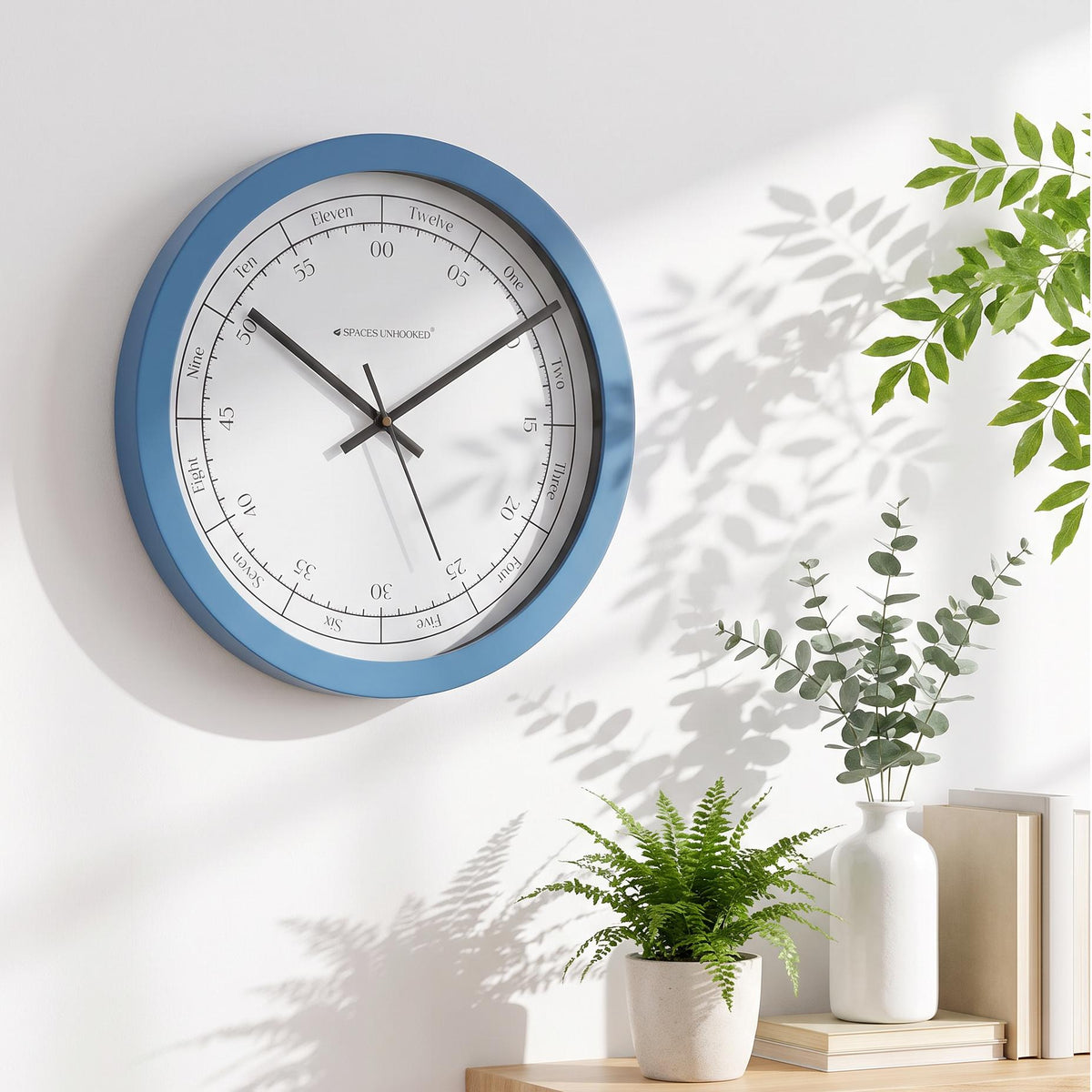 Minute scale numbered 00 to 55 with tiny ticks on a Spaces Unhooked blue round wall clock