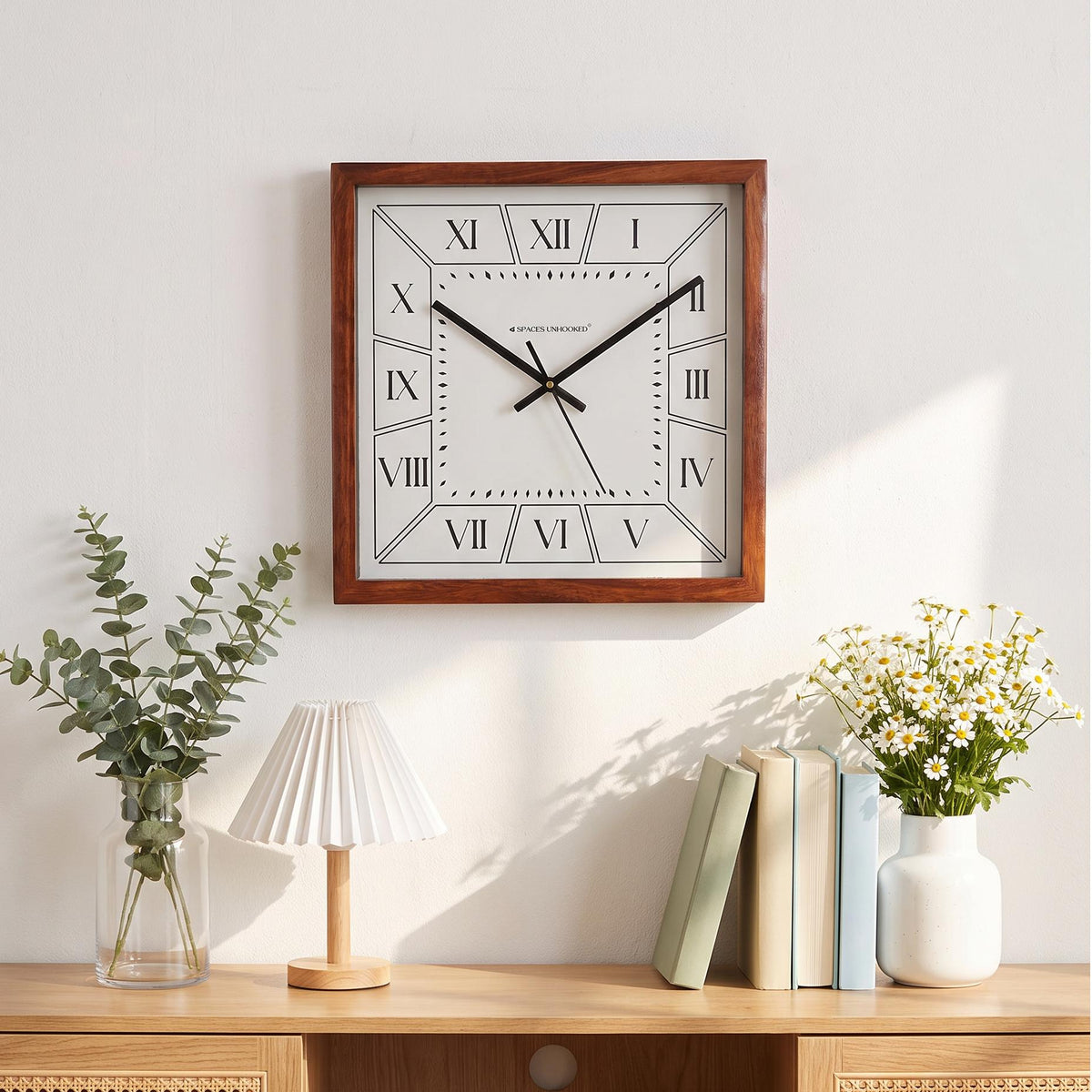 Rich brown wooden frame with visible grain on a square Roman numeral wall clock, close-up