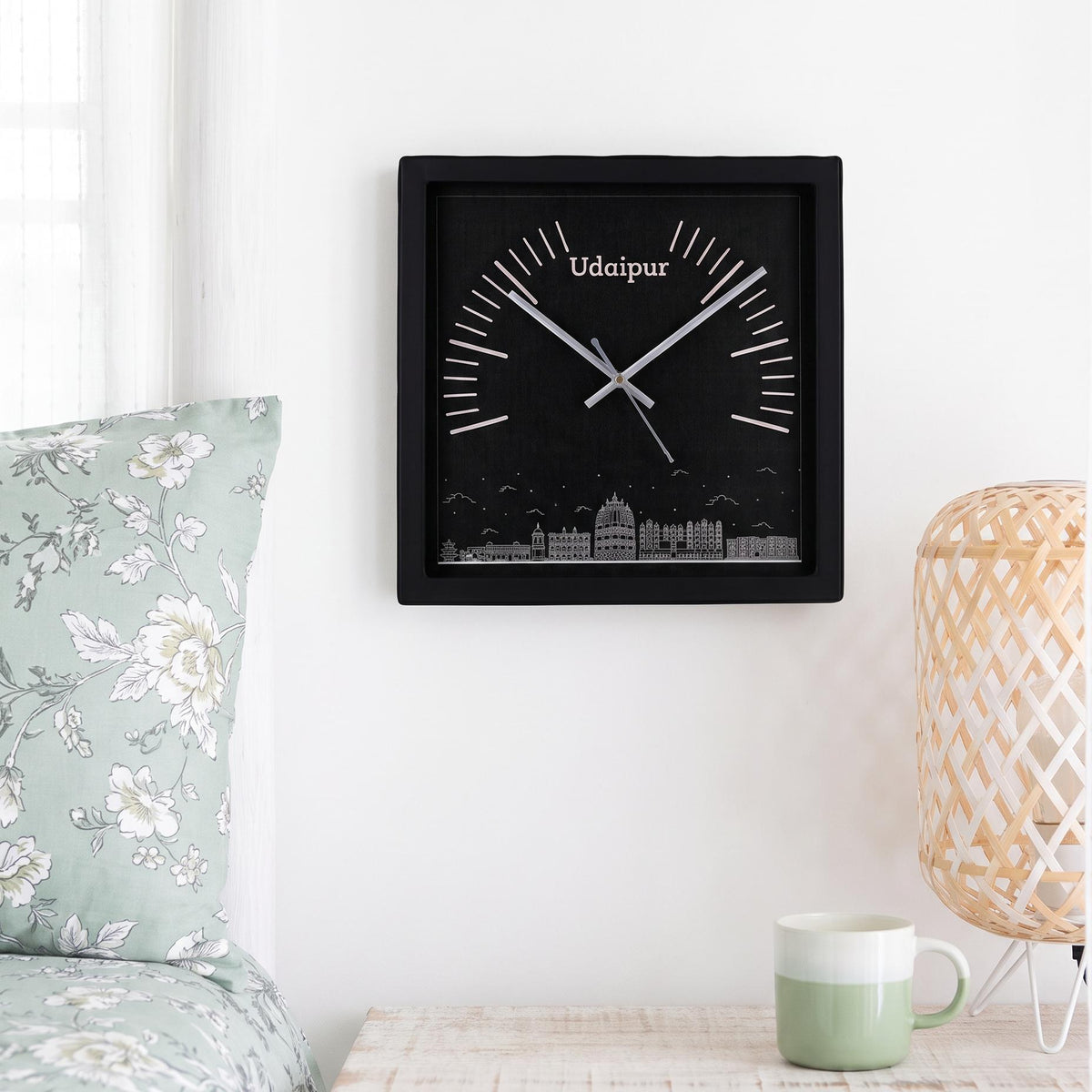 Black square frame and clear cover of a Udaipur skyline wall clock, close-up view
