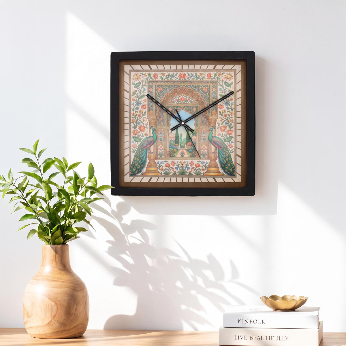 Black square frame and clear cover of a peacock garden art wall clock, close-up view