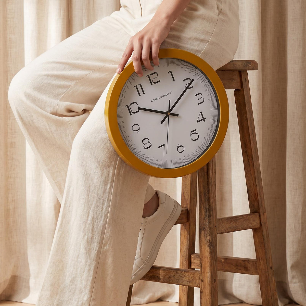 Close-up of the fine ruler-style minute track on the white dial of a yellow wall clock