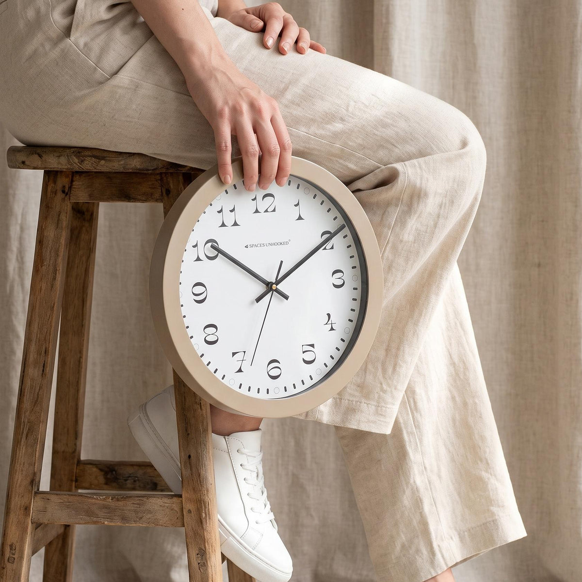 Close-up of ornate high-contrast serif numerals 1 to 12 on a taupe round wall clock