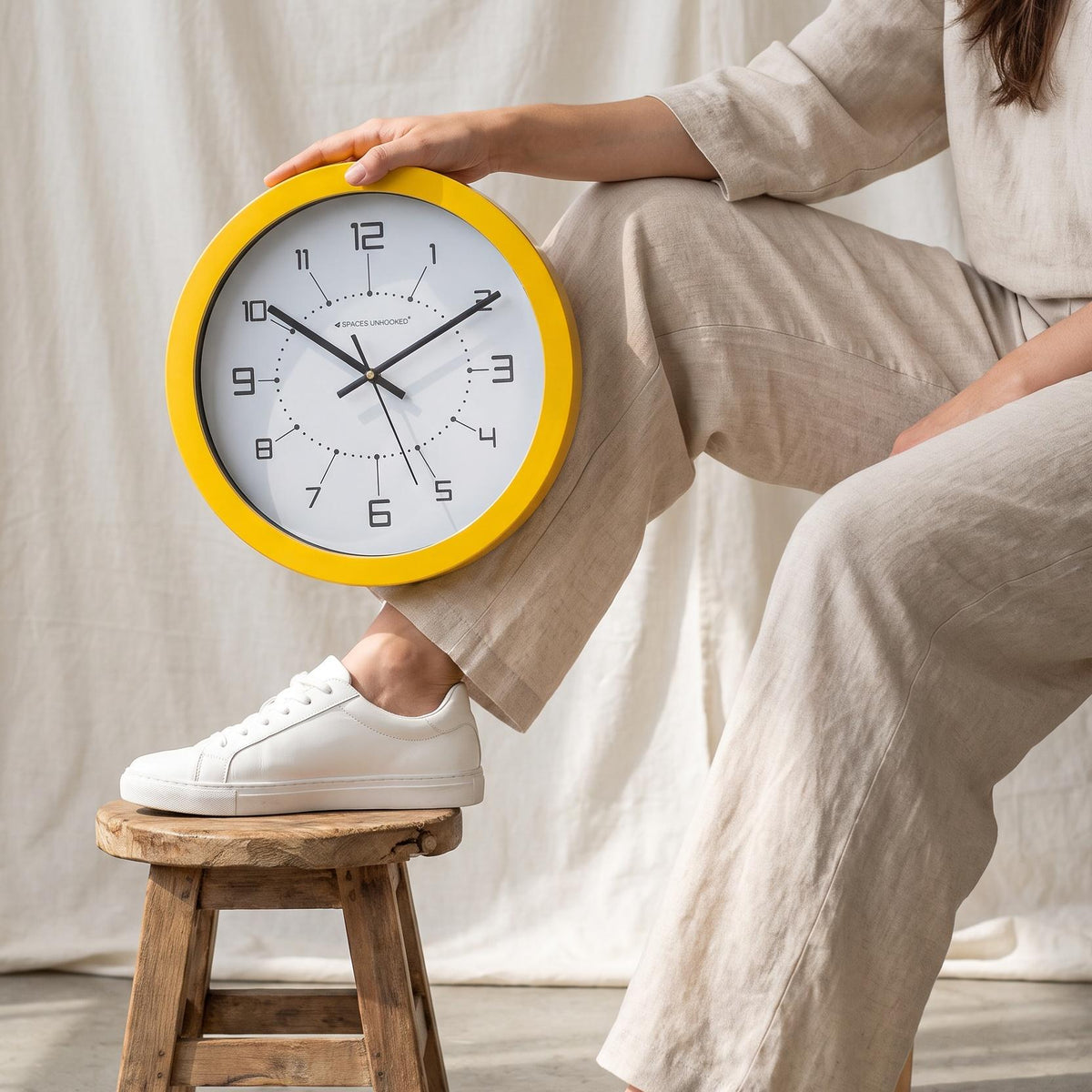 Close-up of the dotted ring and geometric numerals on a yellow round wall clock dial