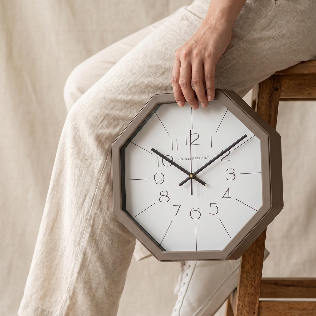 Close-up of slim numerals 1 to 12 near the centre of a white octagonal clock dial