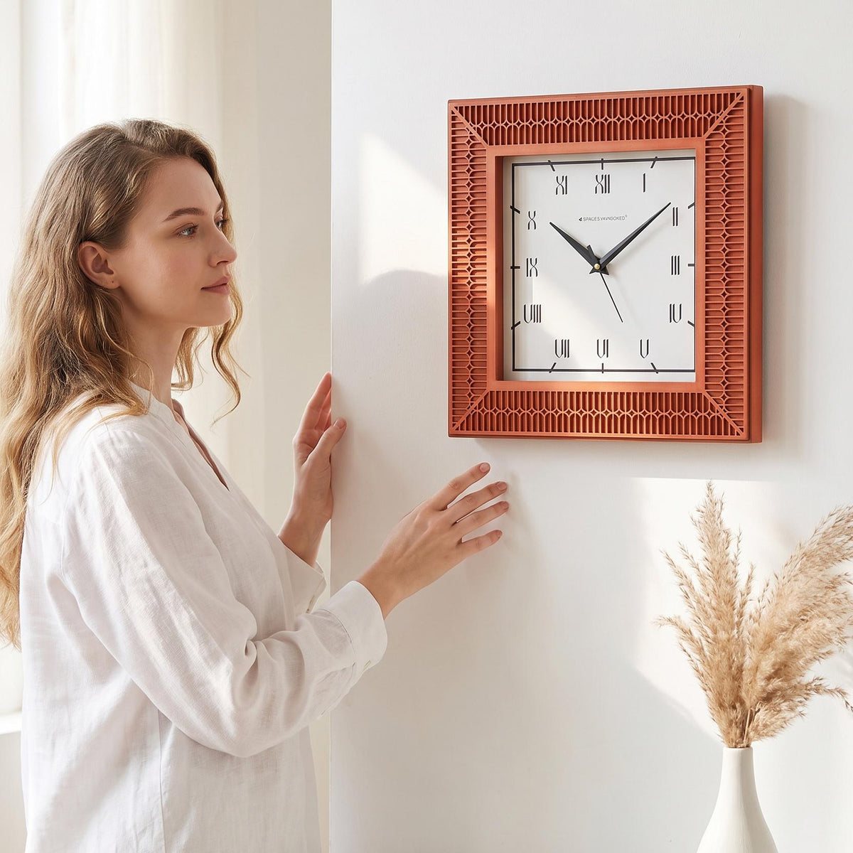 Close-up of slim Roman numerals inside a thin square border on a white clock dial