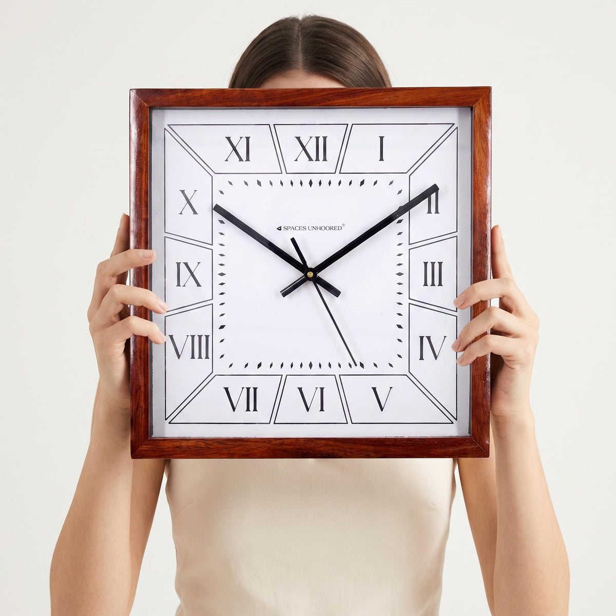 Roman numeral square wooden wall clock hanging above a dining sideboard in a warm home