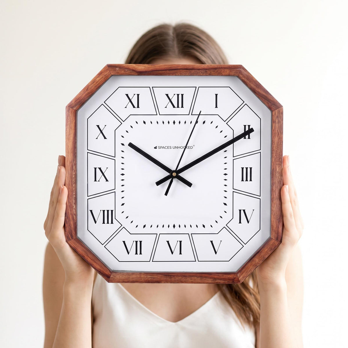 Roman numeral cut-corner wooden wall clock hanging above a dining sideboard in a warm home