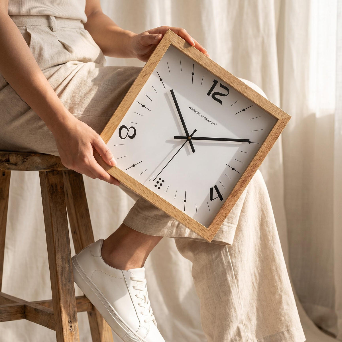 Close-up of bold stylised 12, 4 and 8 numerals on a white square wooden wall clock dial