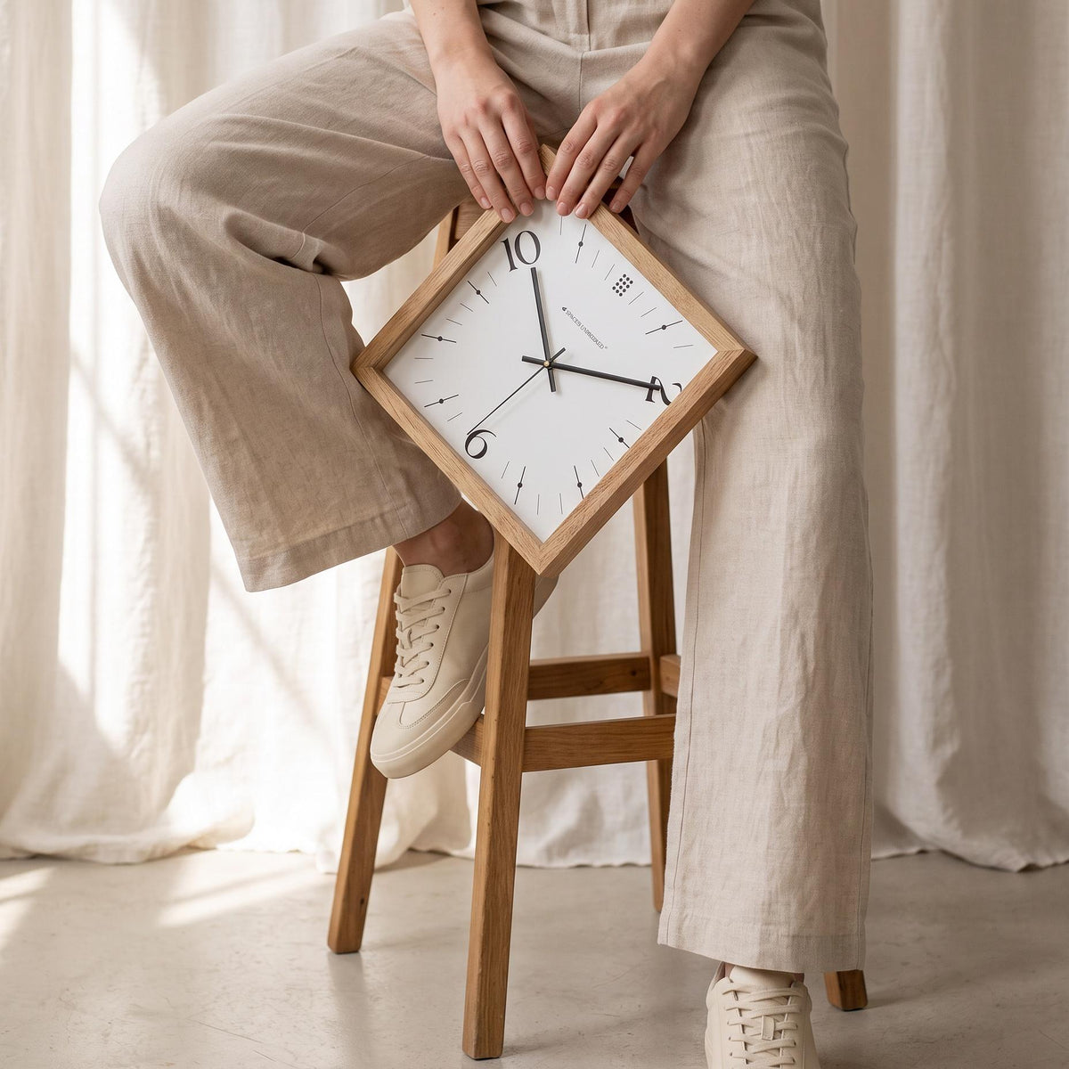 Close-up of oversized stylised 10, 2 and 6 numerals on a white square wall clock dial