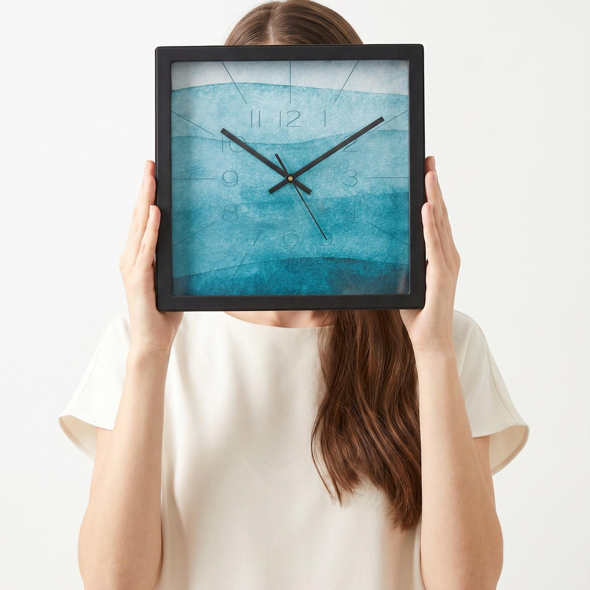 Teal watercolour wall clock above a living room wall above a sofa