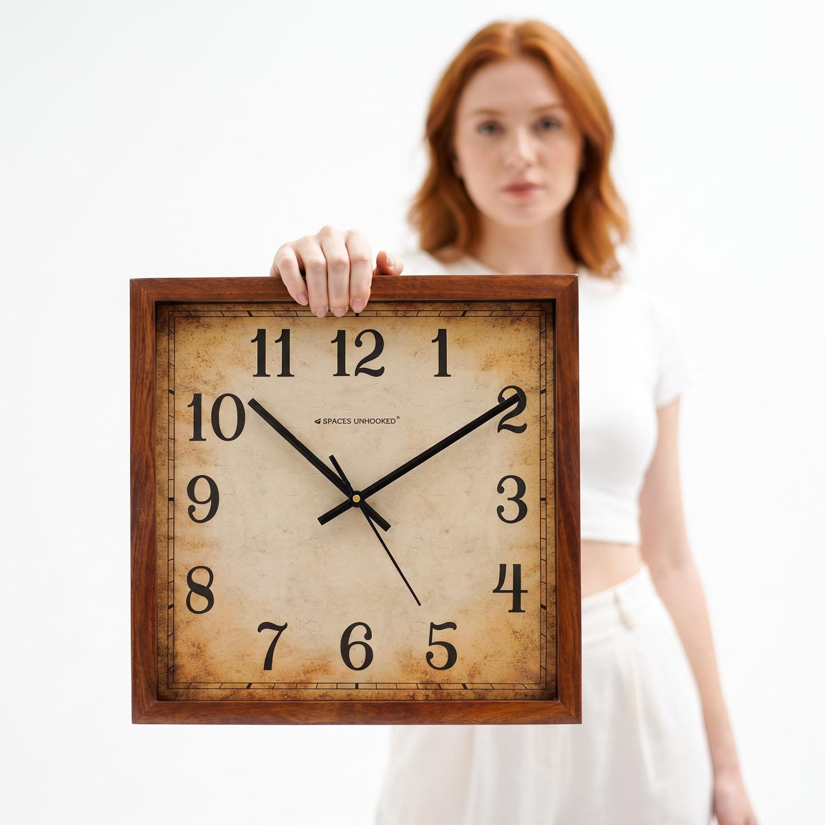 Vintage square wooden wall clock above a wooden sideboard in a warm, cosy living room