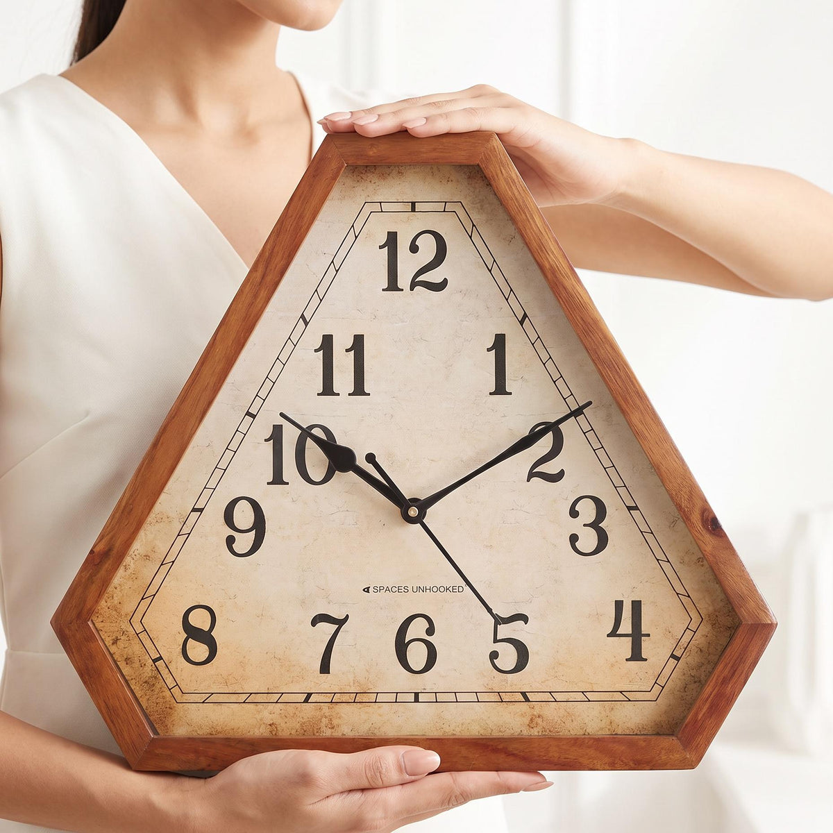 Vintage triangular wooden wall clock above a wooden sideboard in a warm, cosy living room
