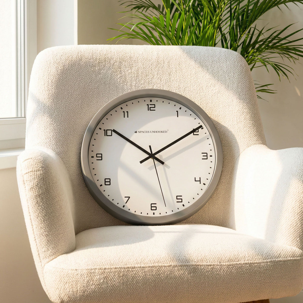 Spaces Unhooked silver wall clock 3/4 view white face bold numerals – contemporary decorative clock living room bedroom