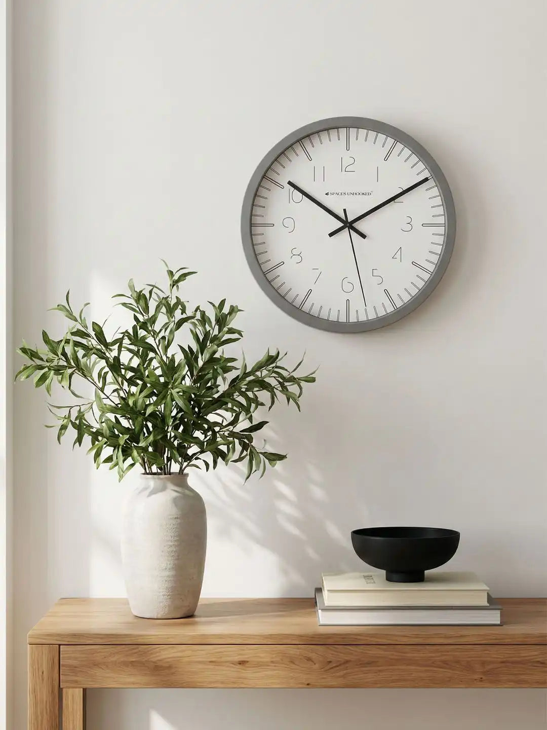 Spaces Unhooked grey silent wall clock displayed on a modern console table with elegant home décor