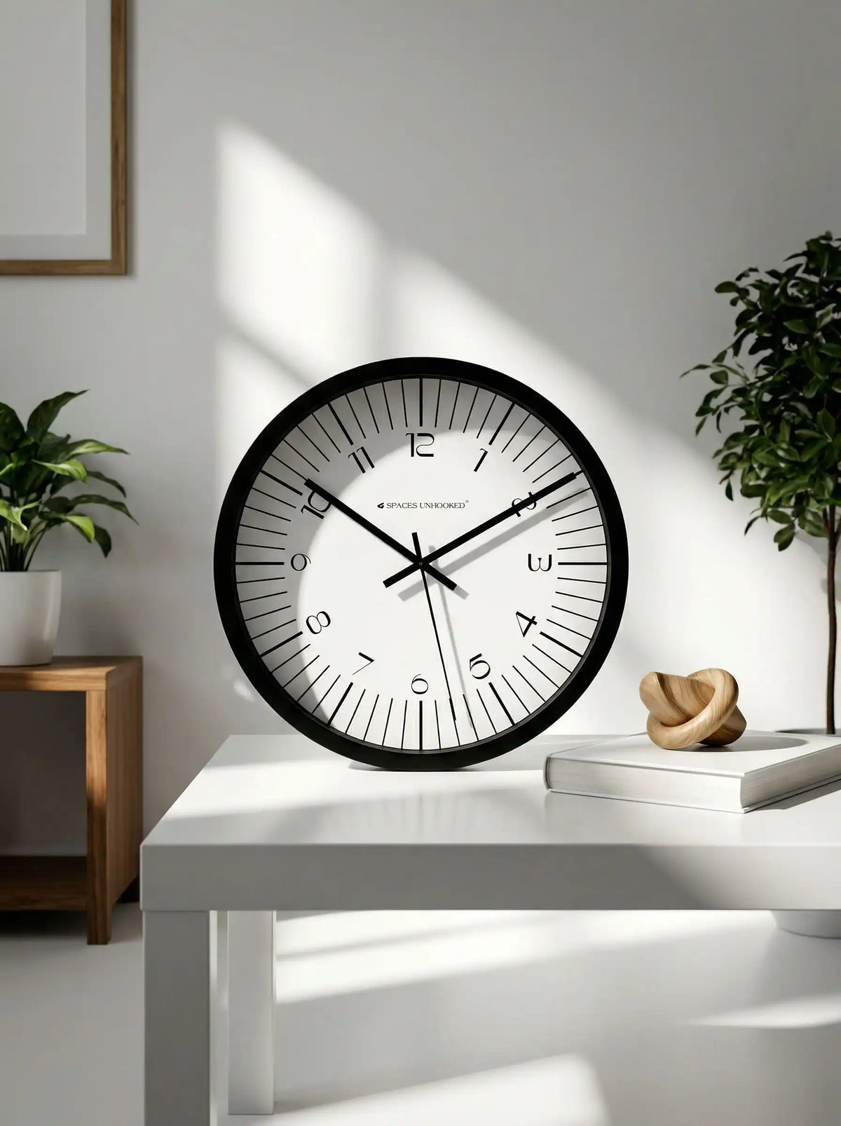 Spaces Unhooked black silent wall clock displayed on a modern tabletop with elegant home décor